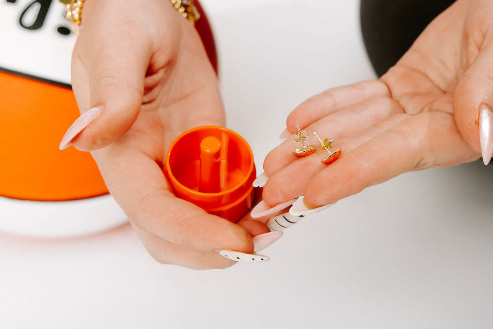 Person holding an orange container with a white background